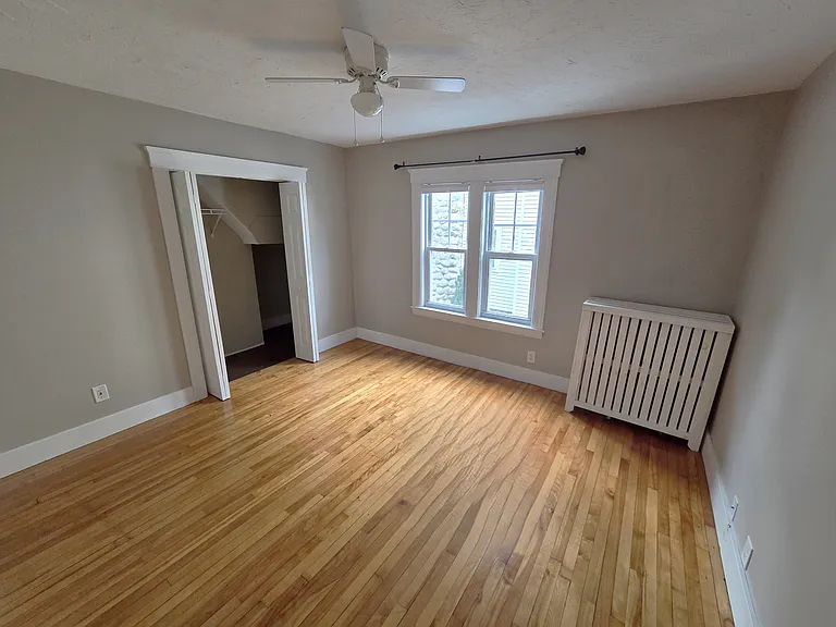 Large bedroom with ceiling fan and closet.