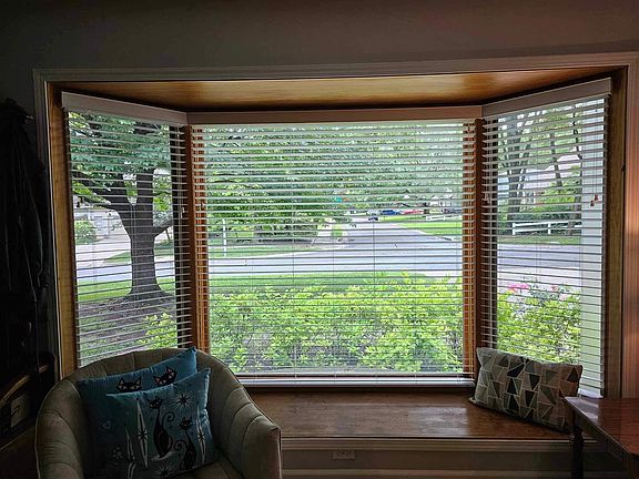 Baywindow with new wooden window blinds and a window sill suitable for sitting.