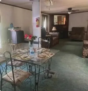 Open living and dining area with ceiling fans, flexible seating, and space for everyday meals and lounging.