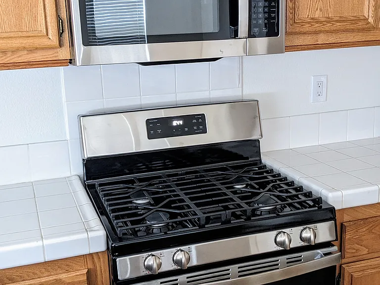 This picture shows the brand new stainless steel appliances in the kitchen (dishwasher, microwave). All of the appliances come with the house.