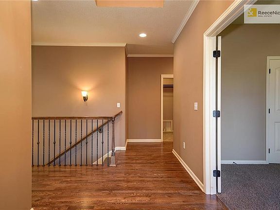 View with second bedroom, stairs to lower level and laundry room.