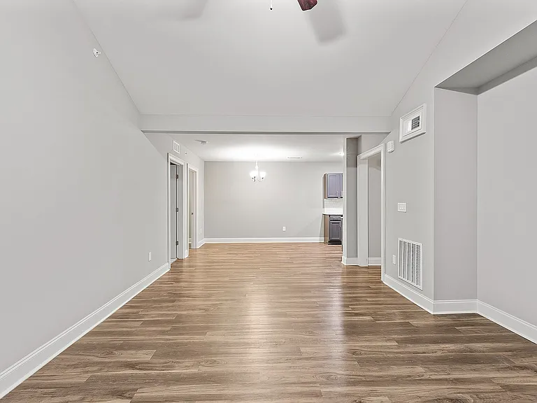 Spacious open-plan living area with sleek hardwood floors and elegant neutral tones.