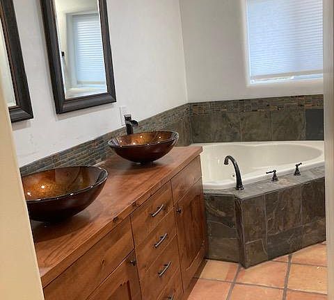 Master Suite bathroom has two sinks, large tub, and separate shower (on right side of this photo)
