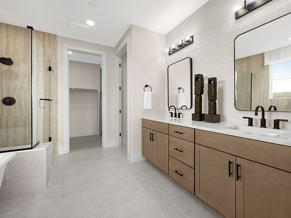 Owner s suite bathroom with dual vanity, glass walk-in shower and freestanding tub