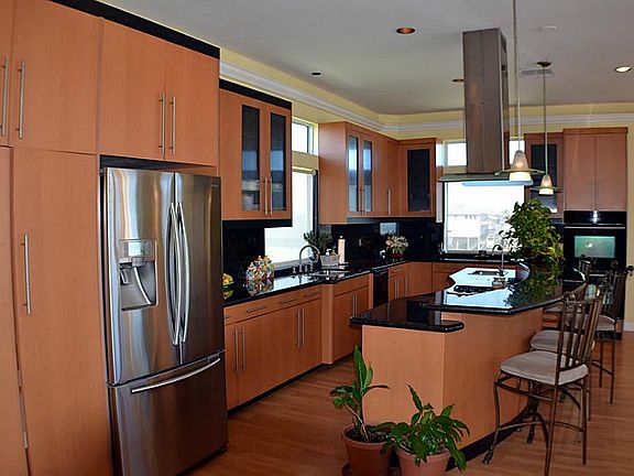 Long kitchen with stainless appliances, granite countertops and an abundance of cabinet space.