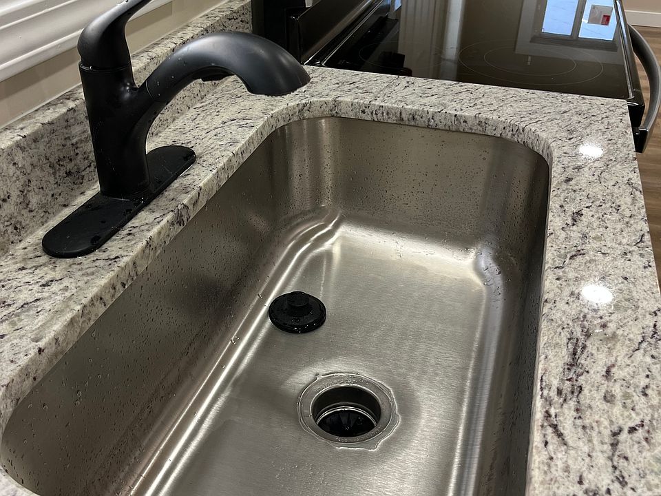Enjoy the large kitchen sink and granite countertop. This kitchen all brand new.