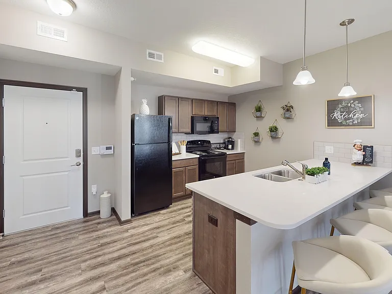 Kitchens include wood-style flooring, a dishwasher, microwave, and a large amount of counterspace.