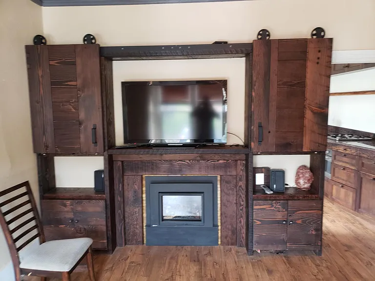 Built in Cabinetry Hiding books and showing TV when yout watch. 100+ year old Wood Victorian Wood on Barn Doors.