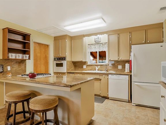 Spacious kitchen with granite countertops and backsplash. Perfect for entertaining!