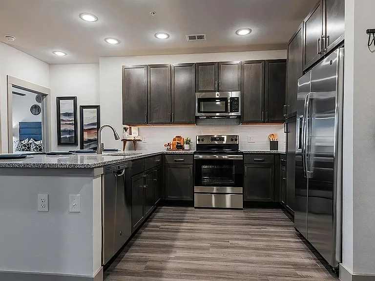 U-Shaped Kitchen with Dark Cabinetry and Granite Countertops