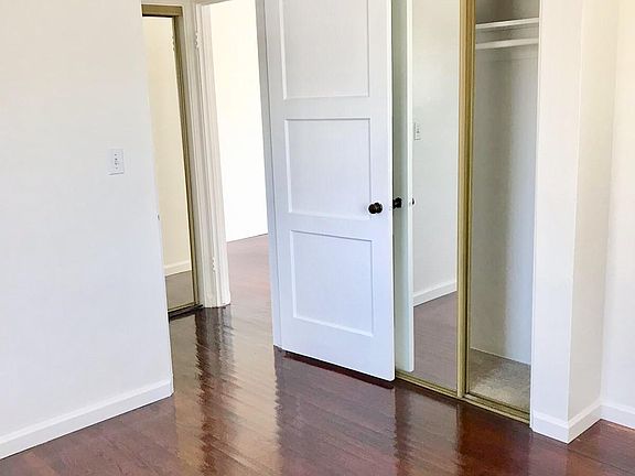 Bedroom with hardwood floors, double closet with mirrored doors..