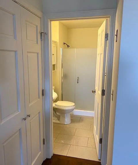 Bathroom with ceramic tile floor and 5 foot shower with heavy glass shower door.