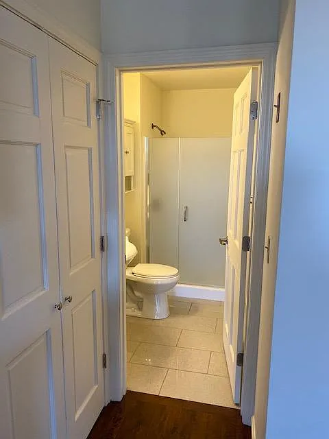 Bathroom with ceramic tile floor and 5 foot shower with heavy glass shower door.