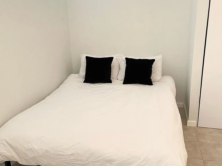 Bedroom with queen sized bed. Partition wall with 1ft open at top to allow outdoor light.