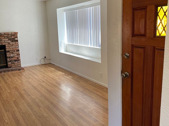 Thru the front door, Livingroom with blinds, fireplace, laminate flooring.