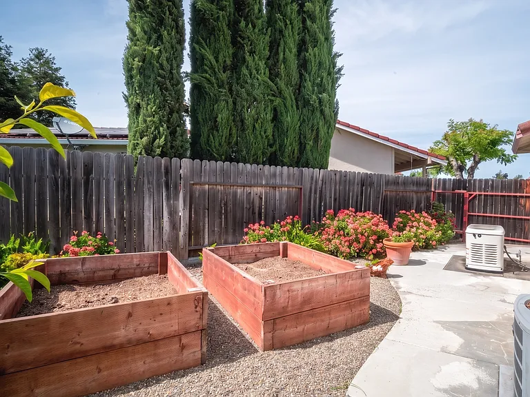 Side yard with raised cedar garden beds ready for planting