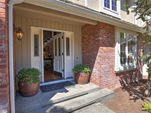 Inviting covered front porch and French doors opens to soaring two-story foyer with gleaming hardwood floors and wrought iron staircase.