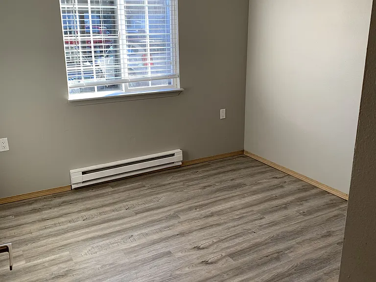 Second guest bedroom in this 3-bedroom home, featuring wood-style flooring, neutral tones, and a bright window. Clean, flexible layout_ideal for guests, a home office, or extra living space.