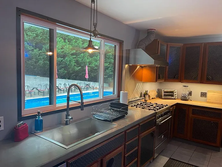 Shared kitchen concrete countertop with pool view