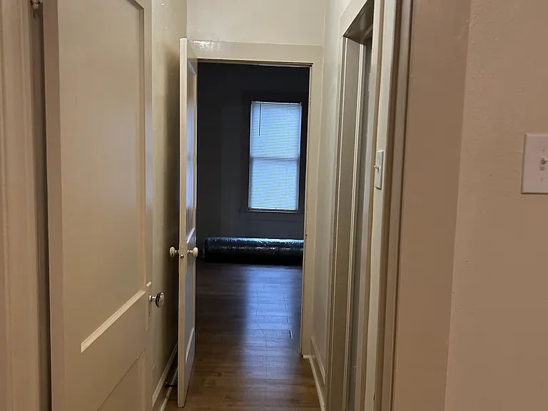 Hallway to bathroom between two bedrooms.