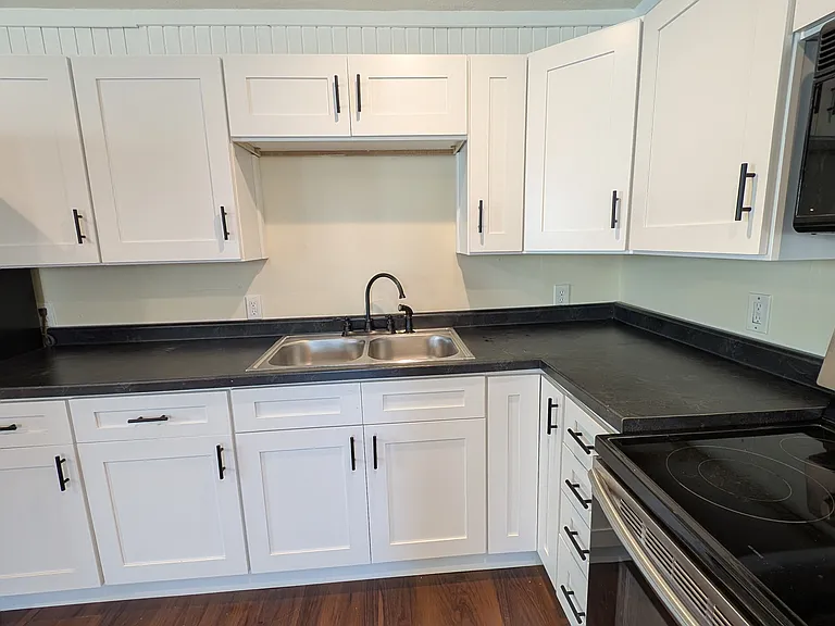 Generous countertop space and upper/lower cabinets offer plenty of room for storage and meal prep in this thoughtfully designed kitchen.