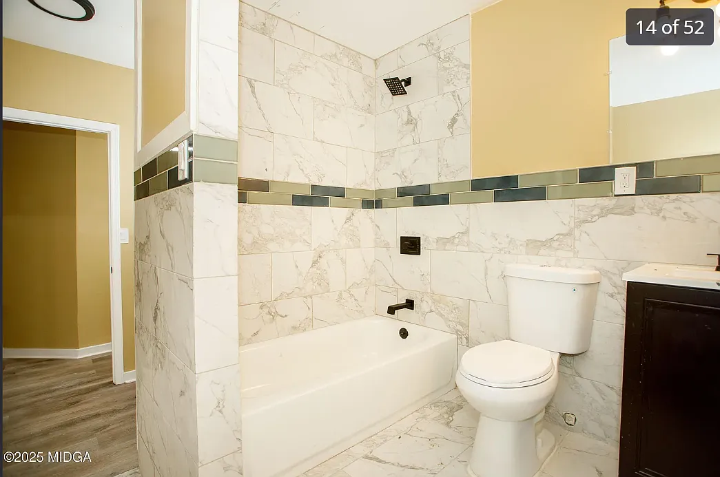 Clean bathroom with a vanity sink, neutral wall colors, and natural light from the window. - 955 Putnam St #1