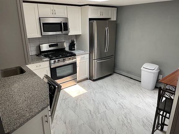 custom eat in kitchen with granite countertops and skylight