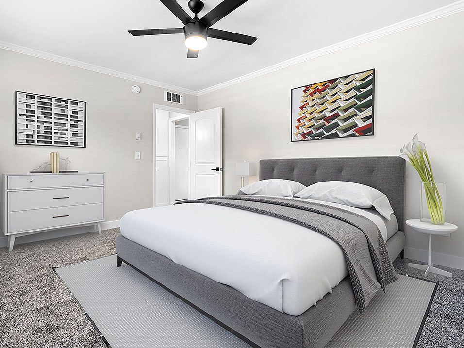 Carpeted bedroom with ceiling fan.