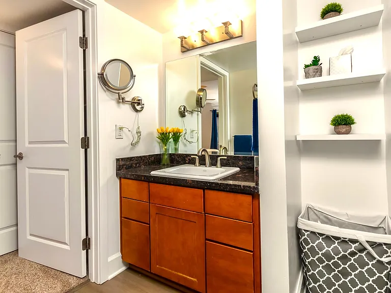 Full bathroom with vanity sink, storage shelves and walk in closet