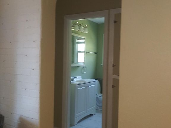 View of bathroom, taken from livingroom, through hall.