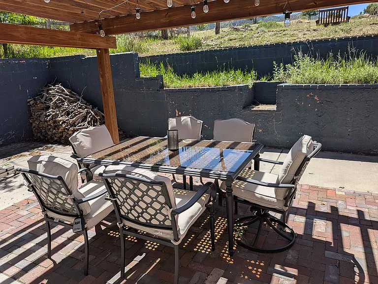Table for 6 on the large brick patio under the trellis