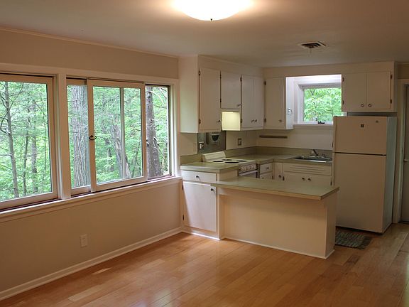 The kitchen with seating for two is open to the living room. Sunset views through the woods every night!