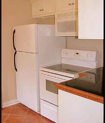 SECOND LOOK OF KITCHEN SHOWING THE STOVE AND THE REFRIGERATO