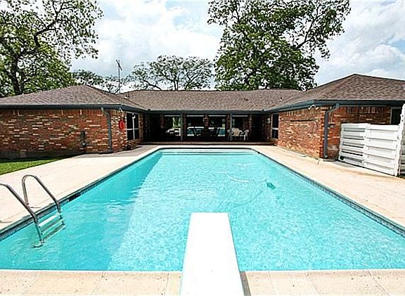 THIS EXPANSIVE BACKYARD FEATURES A GLISTENING POOL