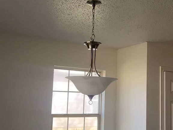 Spacious dining area with modern light fixture.