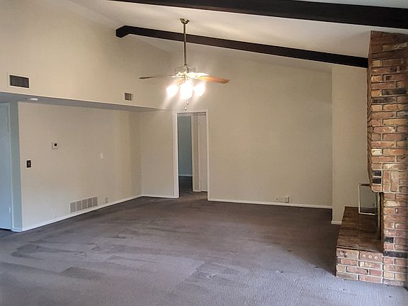 Living Room with fireplace, Bar with Ceiling fan and grey carpet
