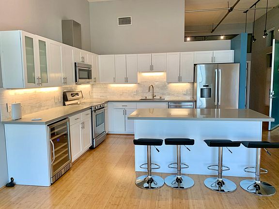 Open-concept chef's kitchen with high-end Bosch appliances, quartz countertops, and a dual-temperature zone wine fridge
