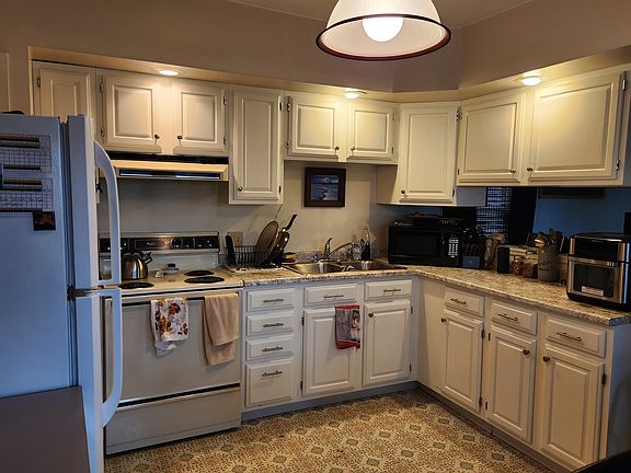 Plenty of lighting, cabinets and counter space. Newer sink and faucet. Electric stove.