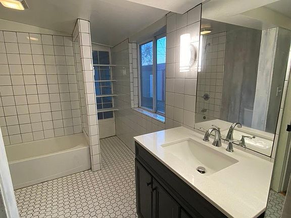 Front full bath attached to bedroom with shutters and family room.