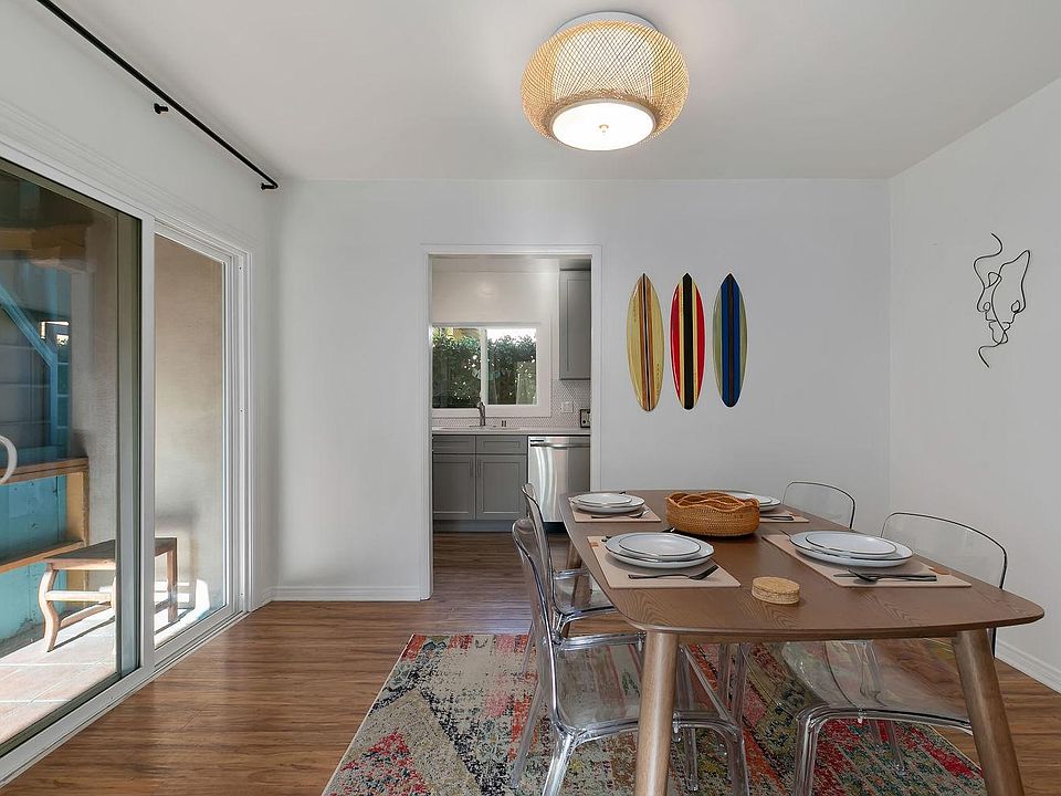 Dining room with view to the kitchen. Second entrance on the left. Screen door opens for cool beach air.