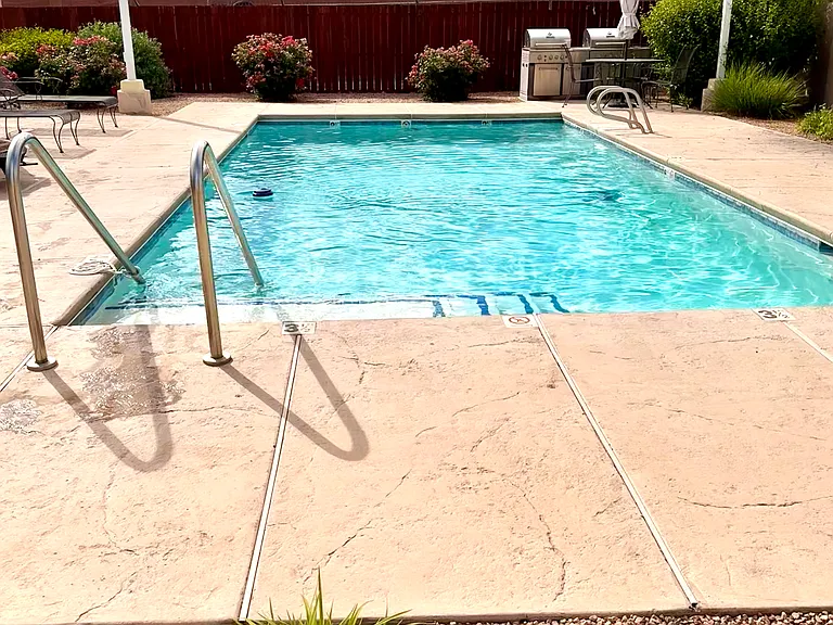 Pool area is landscaped with vibrant flowering plants