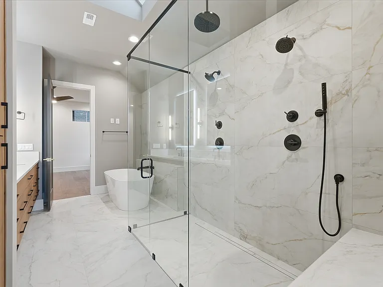 Spa style walk in shower with glass enclosure and premium tile