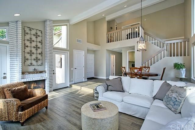 Living room features vaulted ceilings, dramatic fireplace & wood floors