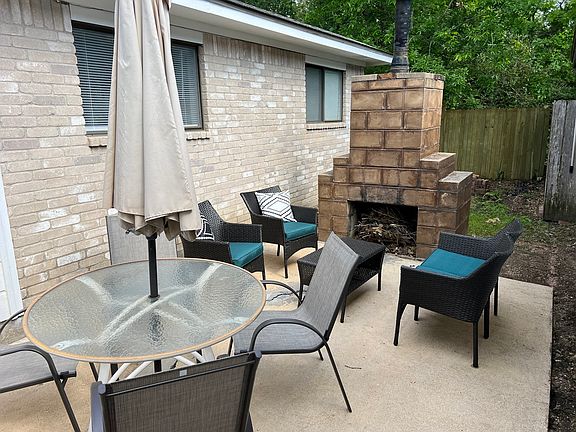 Side yard with patio and outdoor fireplace. Opens to small yard behind fireplace.