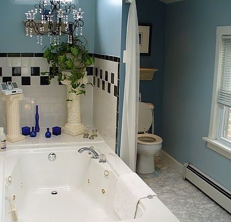 Jetted tub and separate tile shower in main bathroom with marble floors