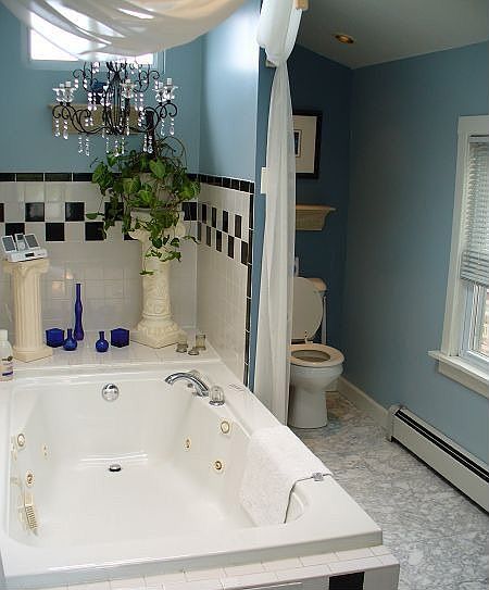 Jetted tub and separate tile shower in main bathroom with marble floors