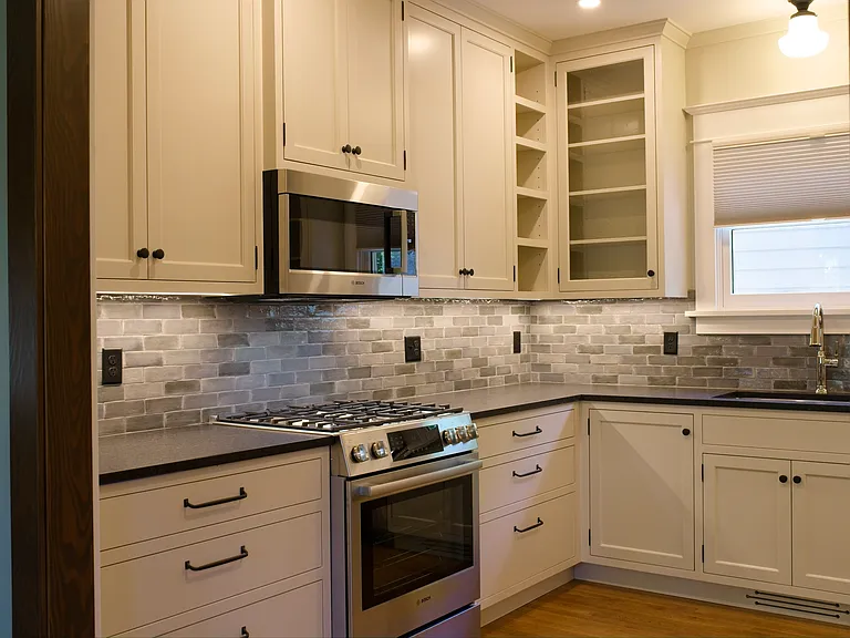 Under-cabinet lighting with granite countertops and tile backsplash
