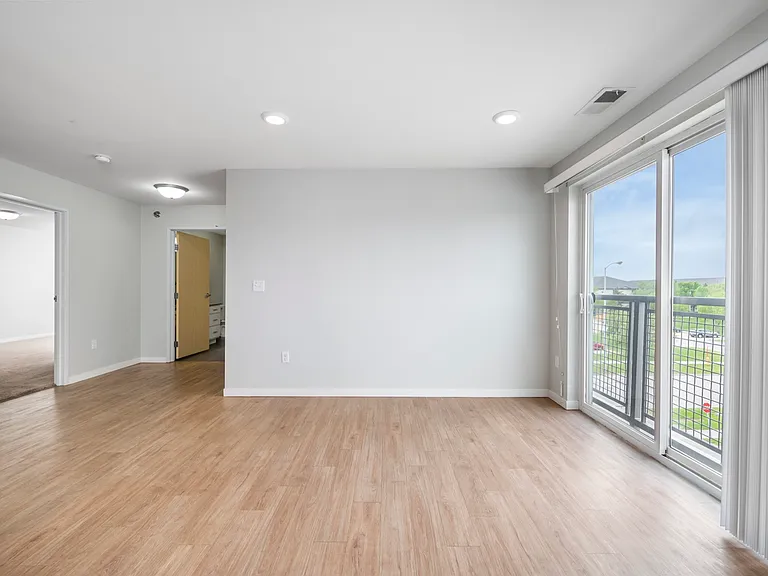 Bright and spacious living area with elegant wood flooring, large windows offering abundant natural light, and access to a private balcony with scenic views. Bright and spacious living area with elegant wood flooring, large windows offering abundant natur