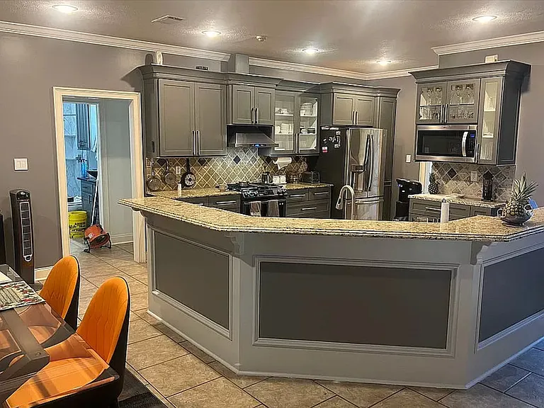Large kitchen with granite top and ample storage.