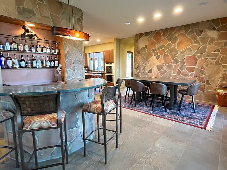 Bar and Dining Area with Kitchen and Hallway to Small Outdoor Area, Elevator, and Master Suite 1 Beyond
